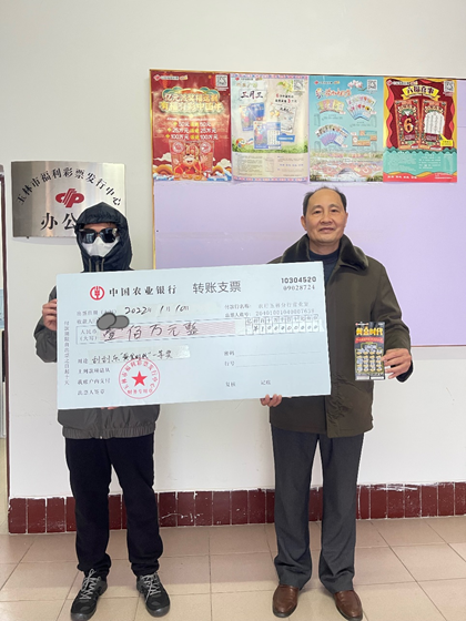 玉林市福彩中心工作人员为杨先生（左）颁奖