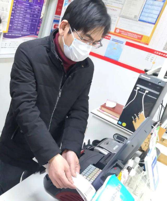 吴忠兵在为购彩者出票 戴新/摄
