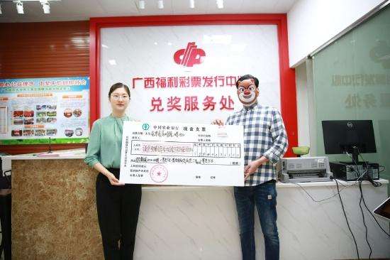 广西福彩中心副主任王瑞琳向得主韦先生（化姓）颁发奖金支票